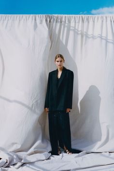 a woman standing in front of a white curtain