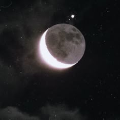 the moon is in the dark sky with some clouds around it and stars on top