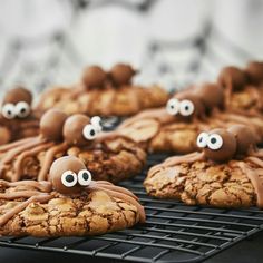 cookies decorated with googly eyes and chocolate icing on a cooling rack for halloween