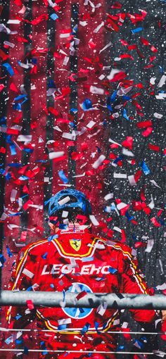 a man in red jacket surrounded by confetti and streamers