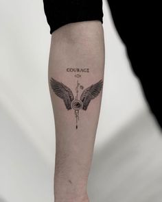 a person with a tattoo on their arm that reads, courage to the blind and has wings