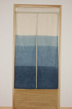 a blue and white curtain sitting on top of a wooden floor