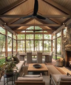 a living room filled with lots of furniture and a fire place under a ceiling fan