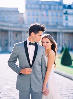 a man in a tuxedo standing next to a woman