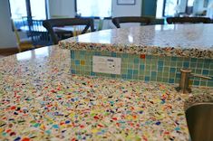 a kitchen counter with multicolored tiles on it