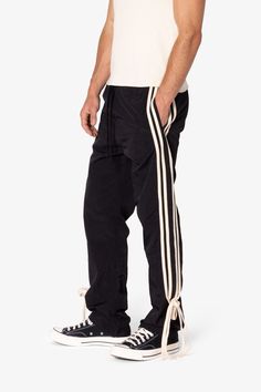 the Tied Stripe Track Pants are designed with a 100% polyester fabric, features a mesh lining, and a contrasting stripe down the side that changes into physical laces you can tie.  details regular fit 100% polyester model is 6’1, 160 lbs and wears a size medium Nylon Pants, Denim Patchwork, Denim Wash, Short Tops, Cargo Shorts, Track Pants, Cargo Pants, Black Pants, Blue Denim