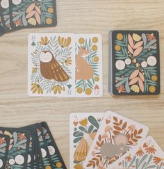 four playing cards with animals and leaves on them