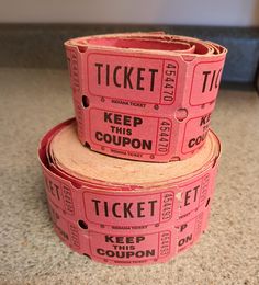 three pink tickets stacked on top of each other