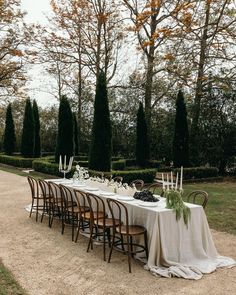 a long table is set up in the middle of a garden