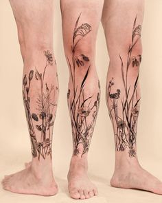 the legs and ankles of a person with tattoos on them are covered in grass flowers