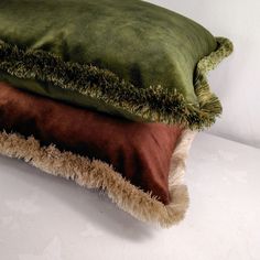 three pillows stacked on top of each other with green and brown colors in the middle