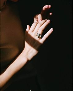 a woman's hand with a ring on her left and the shadow of her right hand