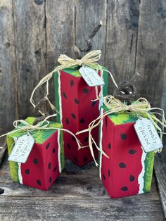 three watermelon gift boxes tied with twine and string, sitting on a wooden surface