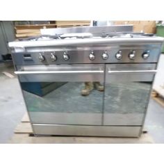 a stainless steel stove top oven sitting in a warehouse