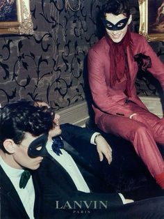 two men in suits and masks sitting on the floor