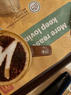 a cappuccino with whipped cream and chocolate is on the table next to a sign