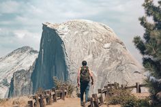 a man walking up a dirt path towards a mountain