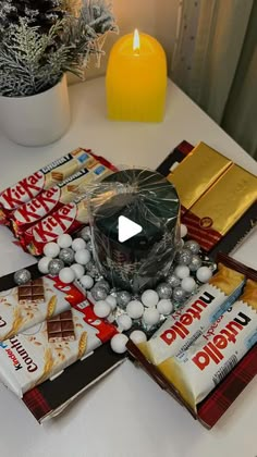 a table topped with lots of candy and chocolates next to a candle on top of it