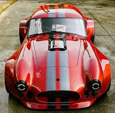 a red sports car parked on top of a parking lot