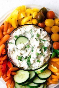 a platter filled with cucumbers, carrots, and other veggies