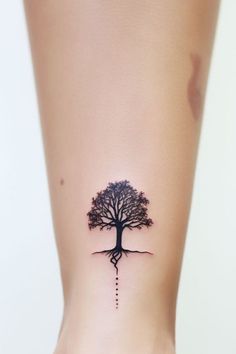 a woman's foot with a tree tattoo on the side of her leg,