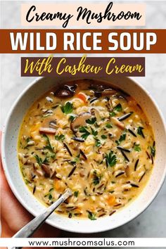 a hand holding a bowl of creamy mushroom wild rice soup with cashew creme