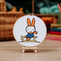 an embroidery project with a cartoon rabbit on a sled