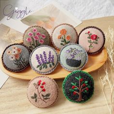 six embroidered flowers are sitting on a plate