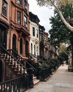 row houses with wrought iron railings and balconies on the sidewalk in new york city