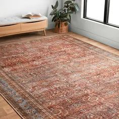 a large area rug in a room with wooden floors and white walls, along with a window