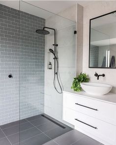 a modern bathroom with grey tile and white fixtures