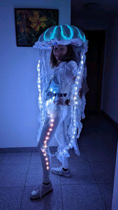 a woman standing in a room with lights on her head and an umbrella over her head