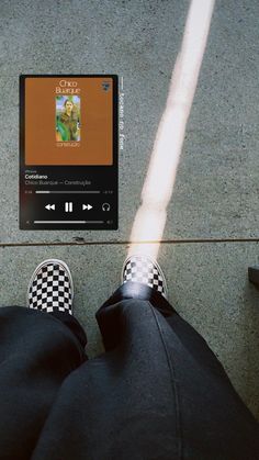 a person with their feet on the ground next to an mp3 player