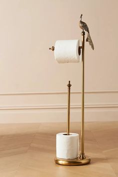 a toilet paper holder with a bird on top and a roll of toilet paper in the middle