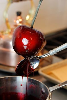 an apple being drizzled with syrup in a pot