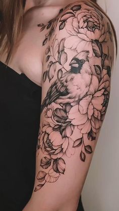 a woman's arm with flowers and a bird on it