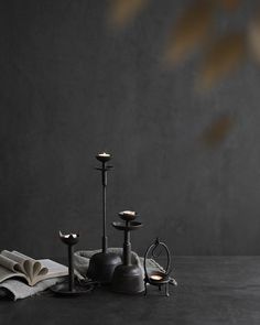 an assortment of candles and books on a table