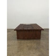 a large wooden box sitting on top of a cement floor next to a white wall