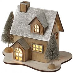 a small wooden house with lights on and trees in the front yard, set against a white background