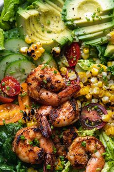 a salad with shrimp, avocado, corn and tomatoes in it on a white plate