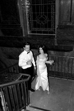 black and white photo of bride and groom walking up the stairs at their wedding reception