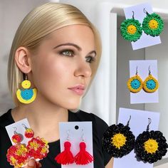 a woman is holding up some colorful crochet earring sets and earrings in front of her face