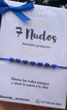 a blue string bracelet with gold beads is being held in front of a sign that says nudos