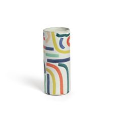 a white vase with multicolored lines on it's sides and bottom, against a white background