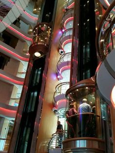 people are standing on the escalator in a large building with many balconies