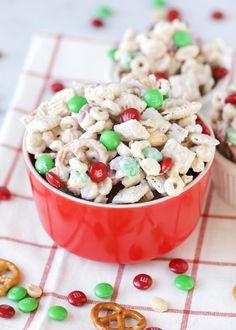 two red bowls filled with cereal and pretzels on top of a checkered table cloth