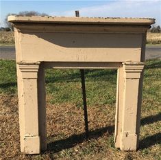 an old fireplace in the middle of a field with grass and dirt on the ground