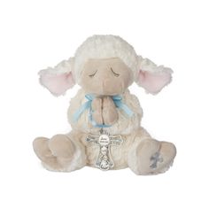 a stuffed sheep with a blue ribbon around its neck sitting on a white background and looking at the camera