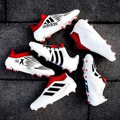 four pairs of adidas shoes laying on the ground next to each other, all in white and red