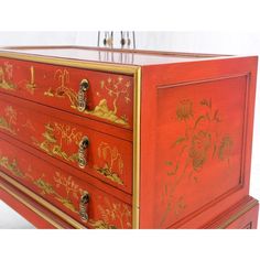 a red and gold painted dresser with drawers